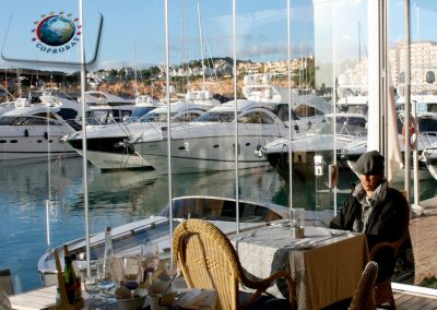 Fermeture d’une terrasse d’un café restaurant à Mèze entre Sète et Agde, Hérault. Les rideaux de verres permettent une utilisation de l’espace extérieur toute l’année.
